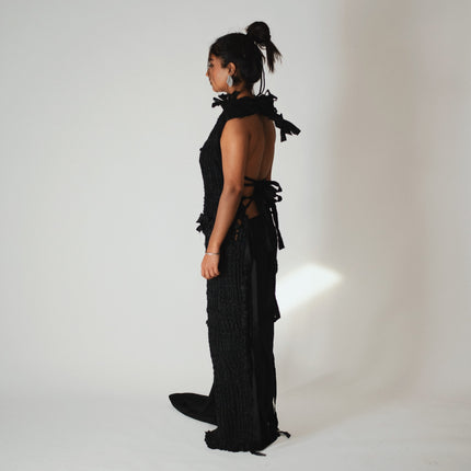 back of the model wearing a black woven dress