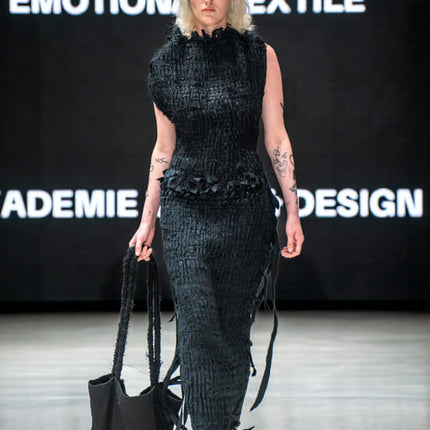 designer woven black dress on a model on a fashion show